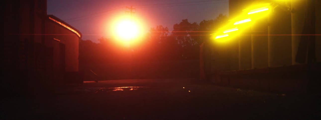 A person jogs outside at night near bright lights
