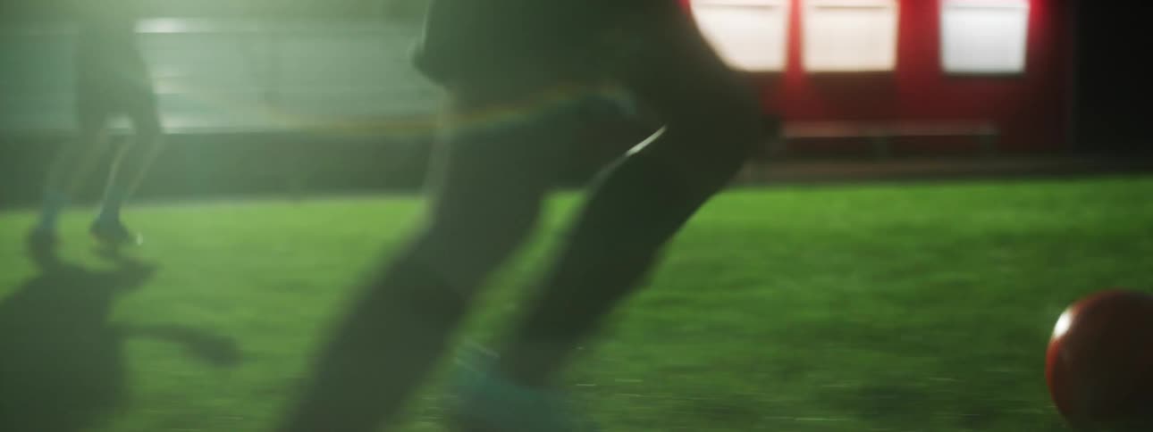 Two people kick the ball