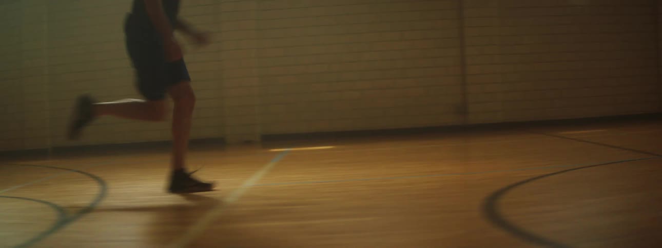 The boy runs down the gym