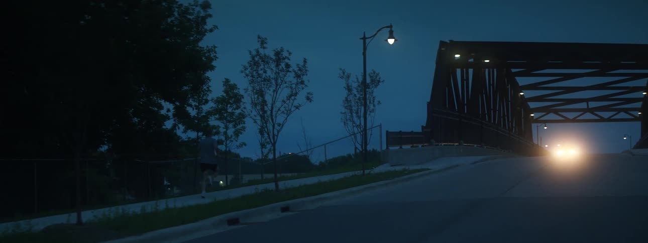 A vehicle travels a over a bridge at night