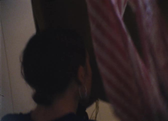A young girls walks through material hanging from the ceiling