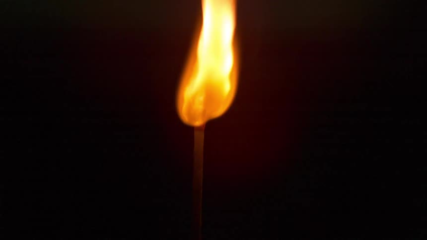 The match is slowly burning in the dark room