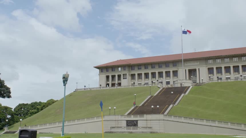 A government building with a flagpole and flag in front of it