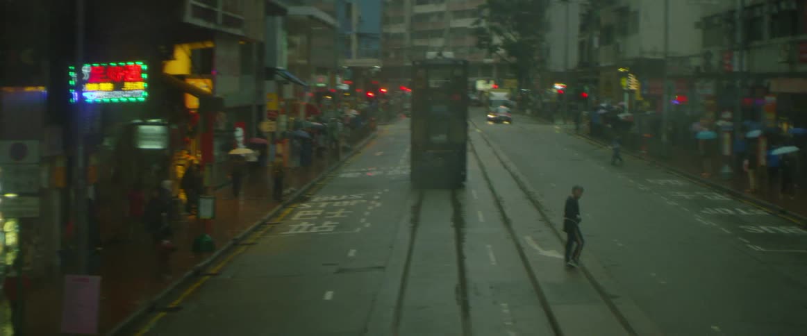 A pedestrian crosses a street while raining in city downtown