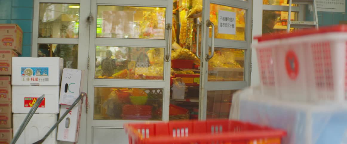 Man enters store through glass door past boxes and hand carts
