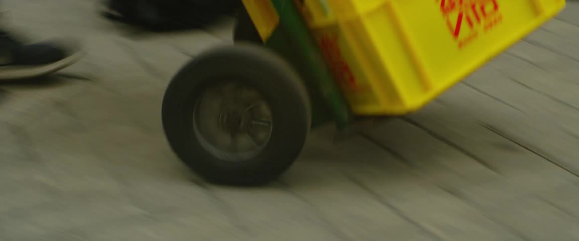 A person delivers a stack of crates to a business in the city