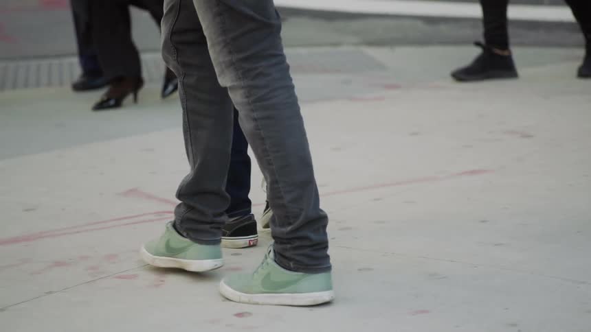 Several people walk on the pavement