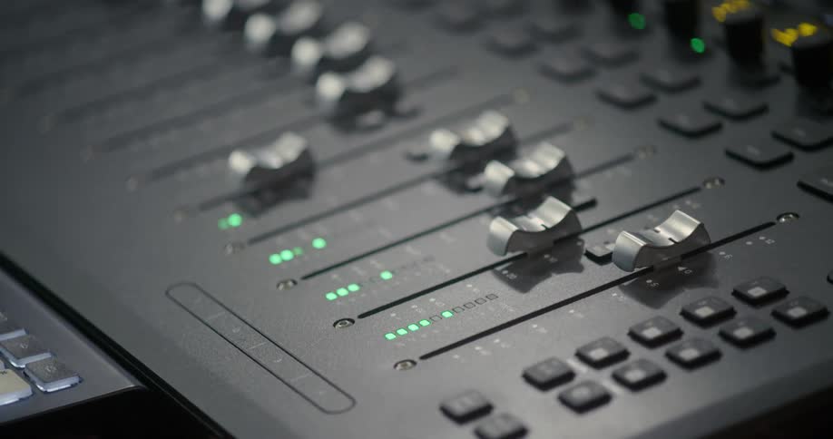 Green leds flashing on sound mixing device covered in sliders and buttons