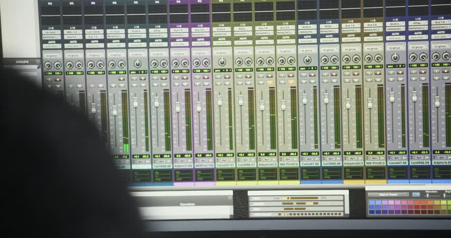 A employee in a music studio sits in front of the equipment