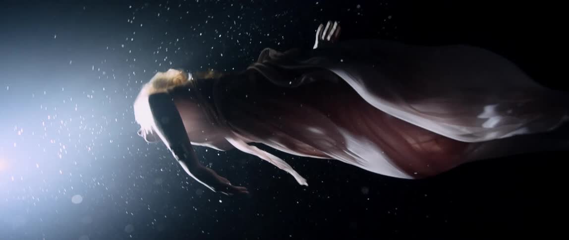 Woman wearing a pink dress dancing underwater