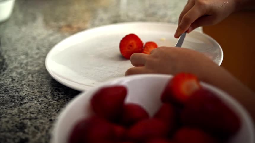 A child cuts strawberries