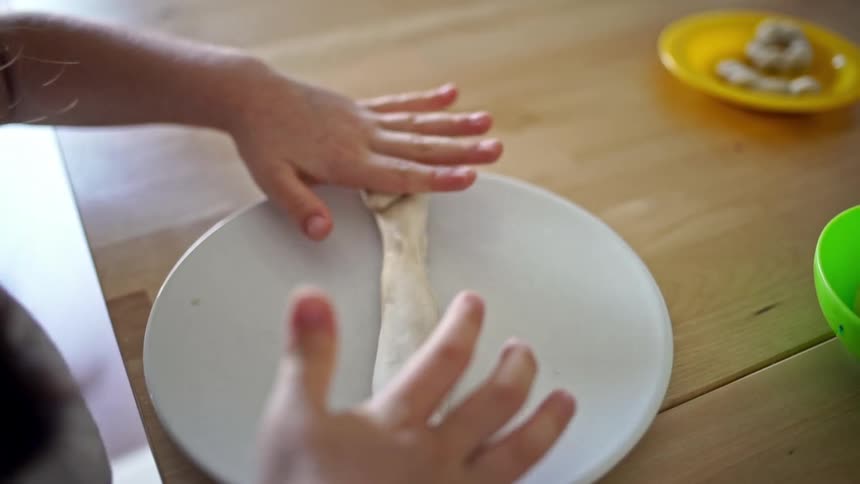The girl works on the dough