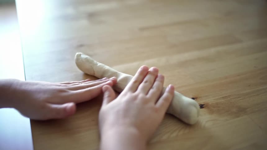 The child rolls the dough