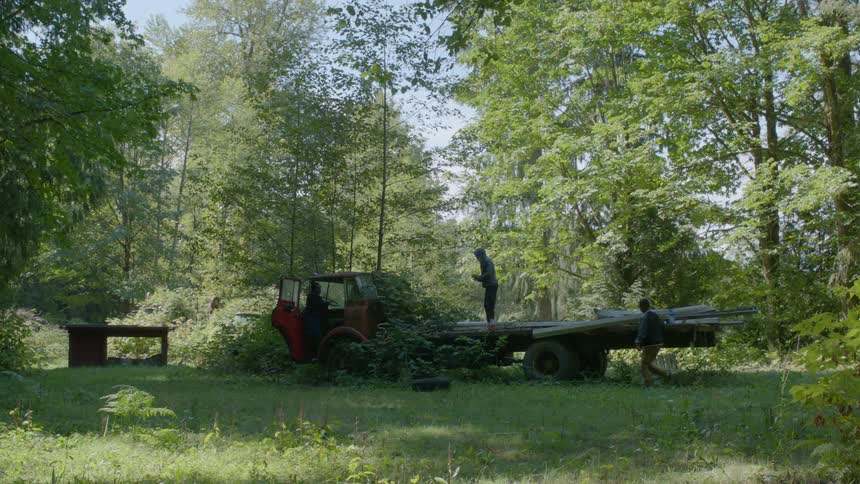 A man throws a tire off the truck