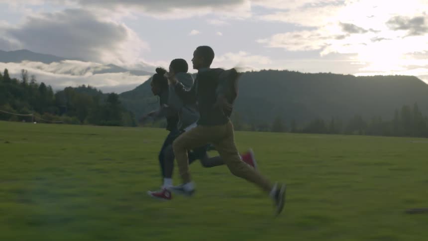Three teens race each other outside