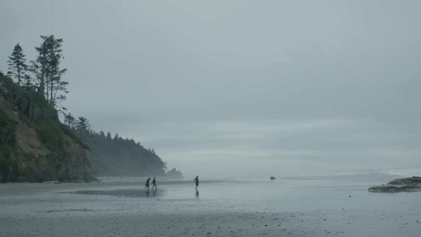Three friends wade into the ocean