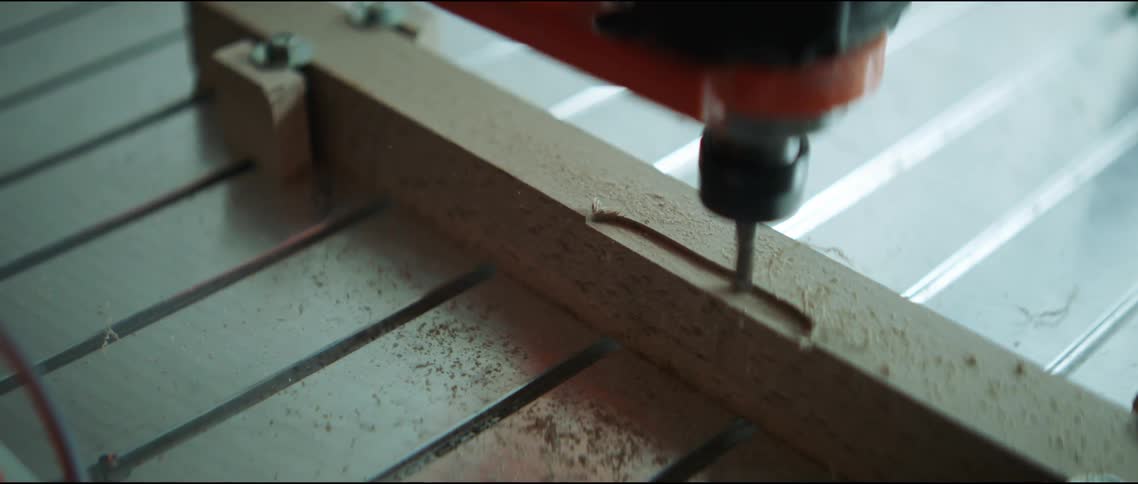 A person uses a dremel on wood