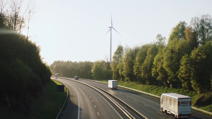 Trucks and cars drive down a divided roadway