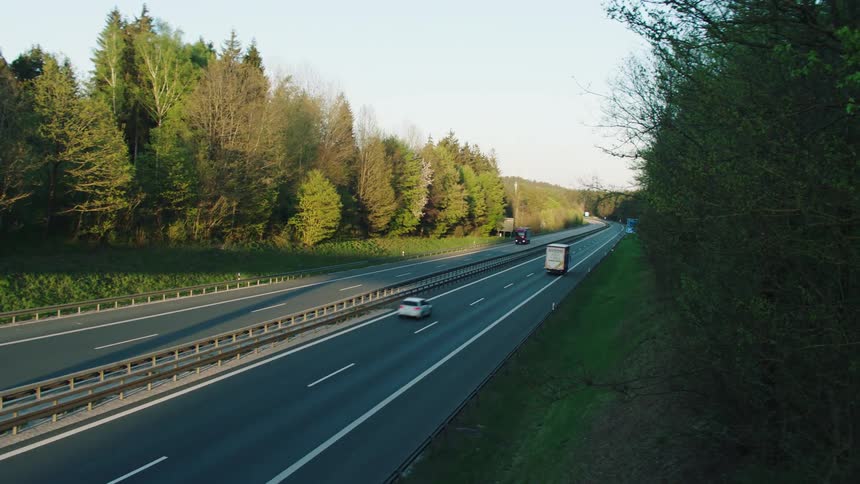 Light traffic on four lane freeway through trees