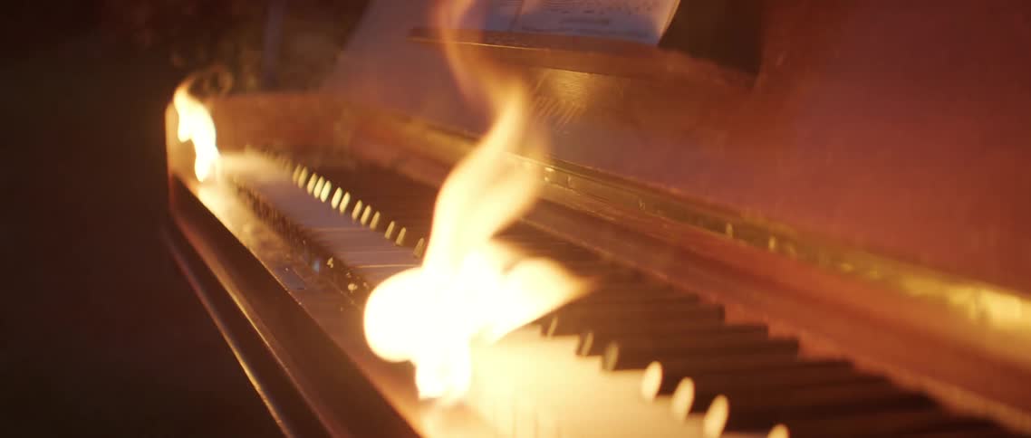 Flames consume a piano keyboard