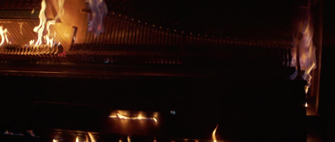 A piano burning in a dark room