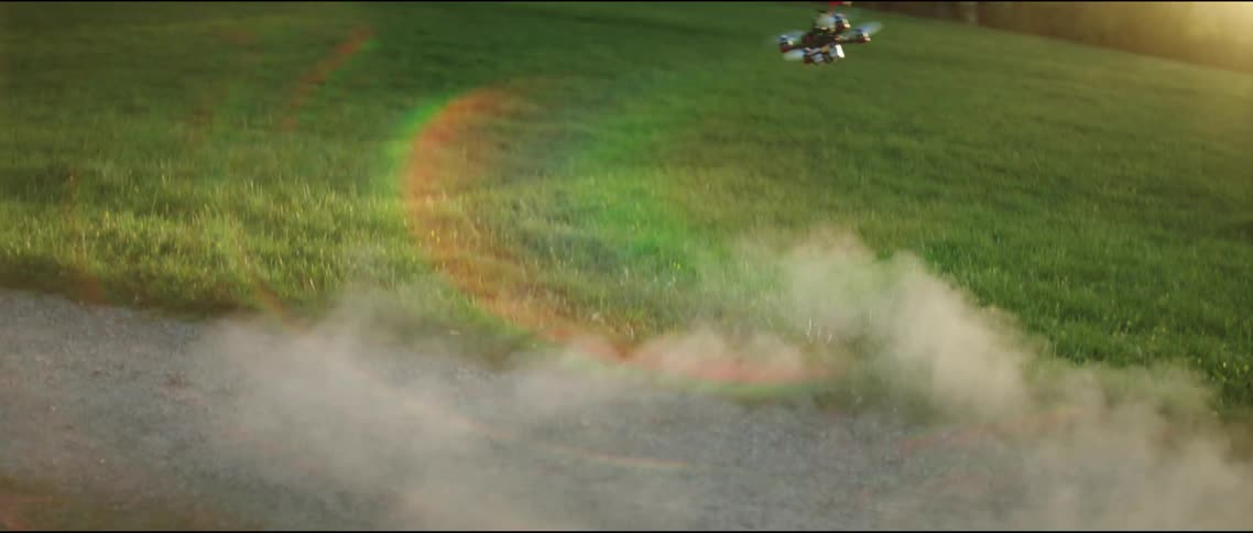 A drone lifts off the ground and flies through the air