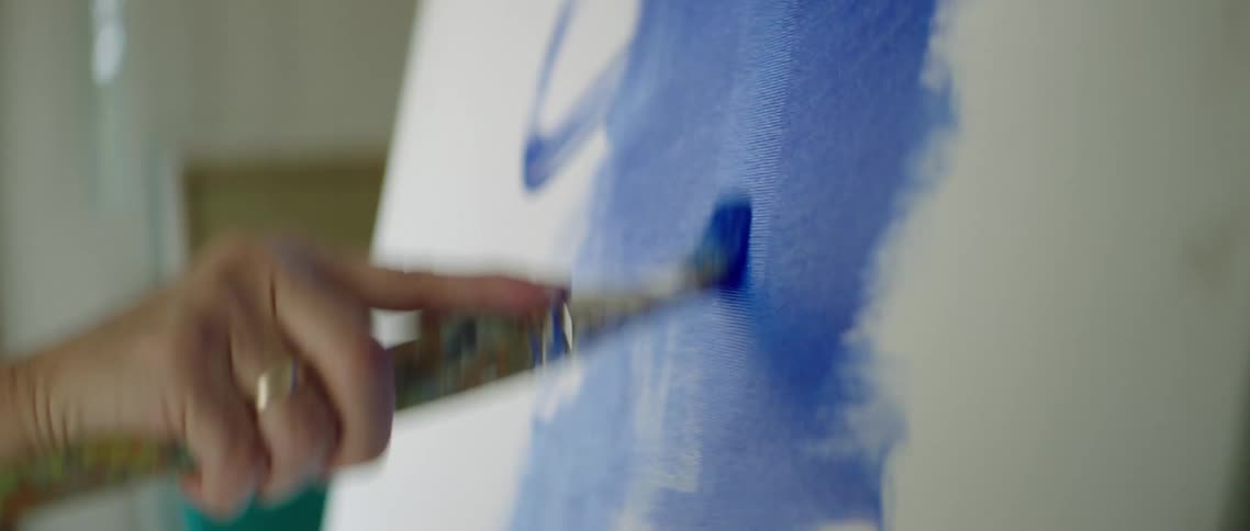 A man paints on a canvas