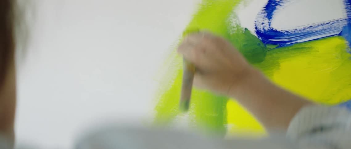 Painter uses a brush to paint on canvas