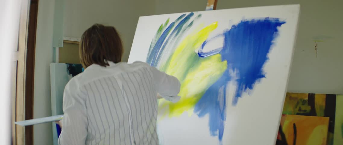 A man paints on a canvas