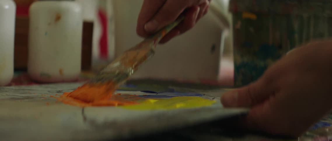 A person is mixing paint with a brush