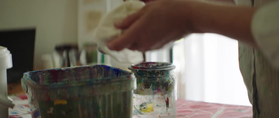 The person cleans the paintbrush