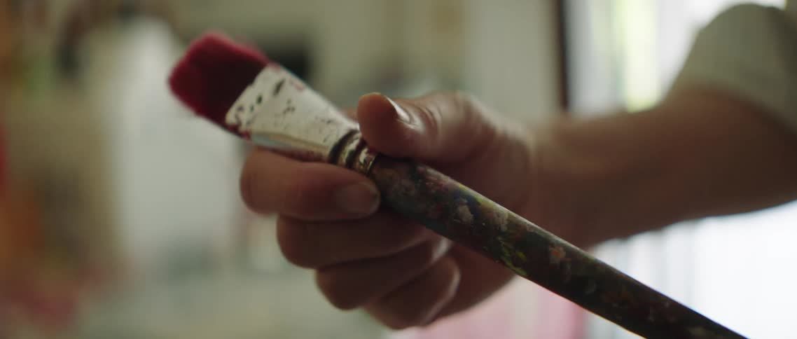 A man examines a paint brush