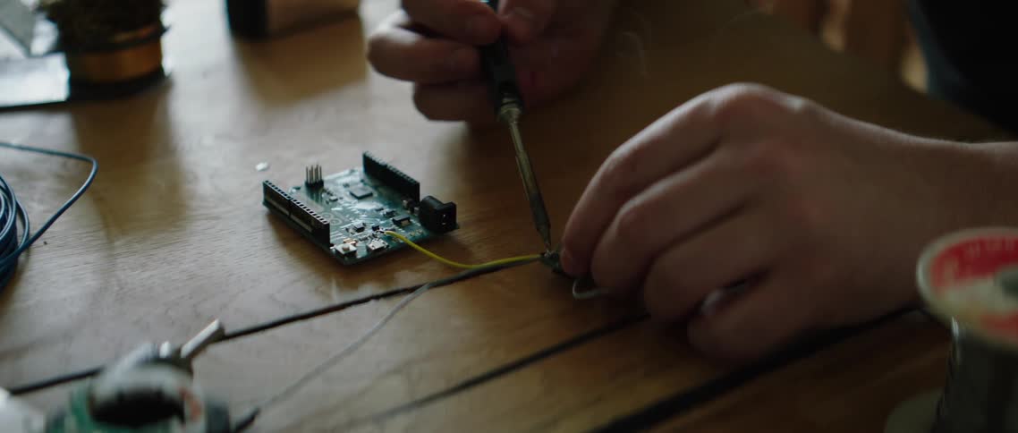 A person using a soldering iron on an electrical component