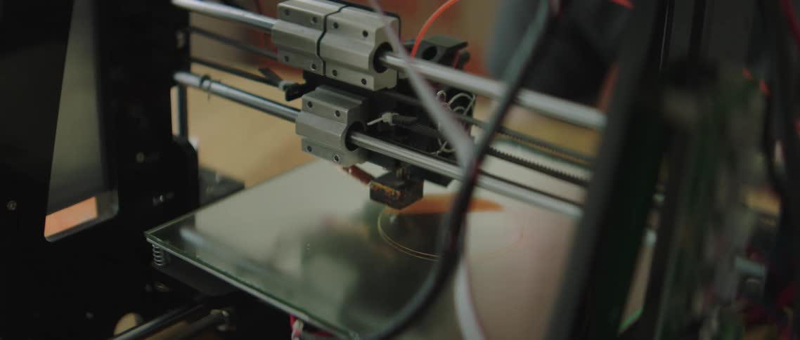 Machinery in a shop is used to cut and engrave a circle on a piece of glass