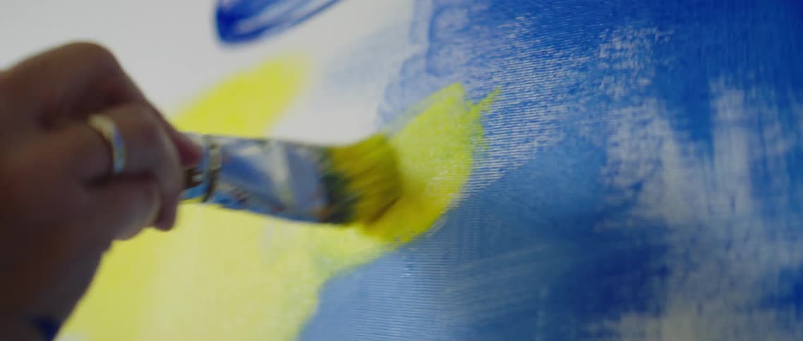 A man paints on a canvas