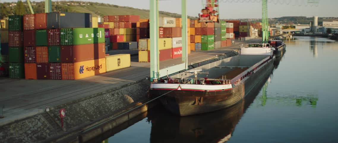 The crane lowers on the freight ship
