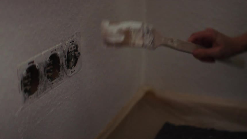 A woman paints inside her house