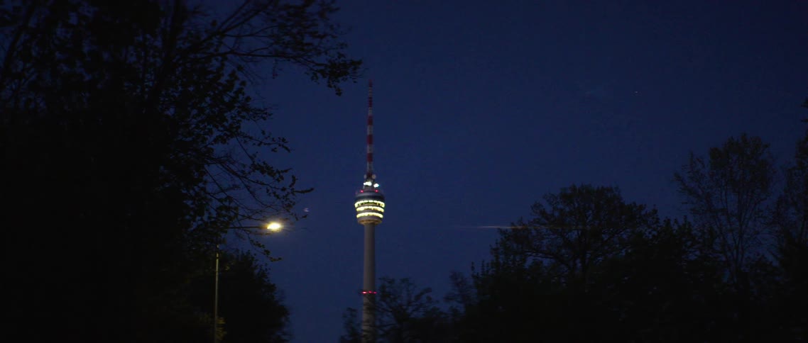 A tower lit up at night in a city