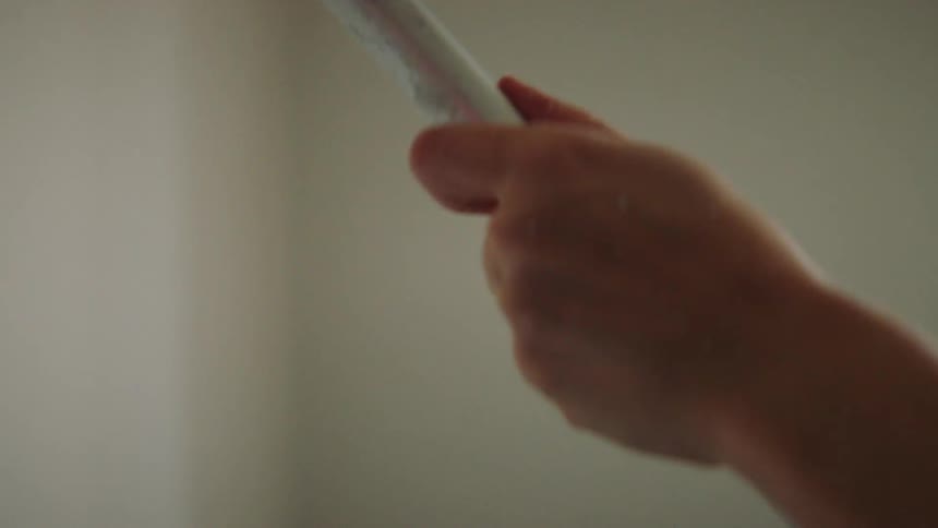 A person using a paint roller to paint a wall