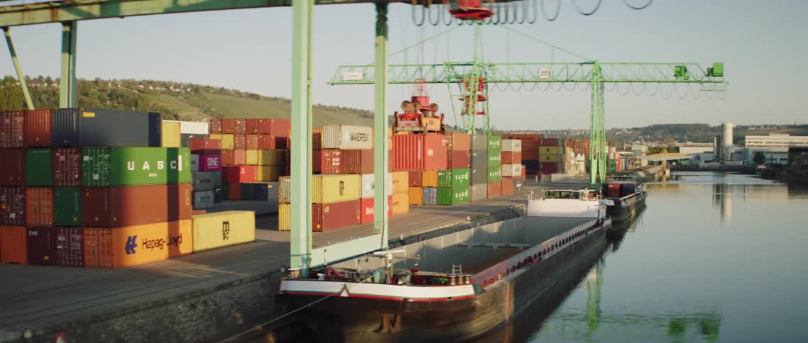 Crane lifting shipping container in shipyard