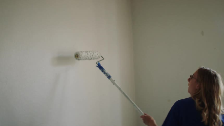 The woman paints the walls