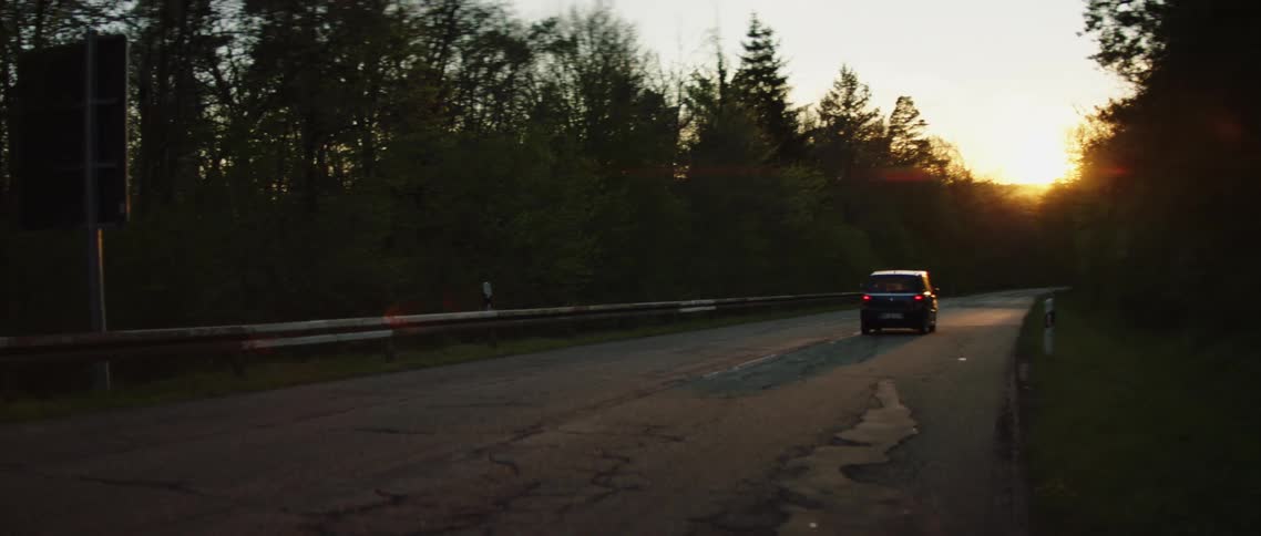 A vehicle driving on a road with trees