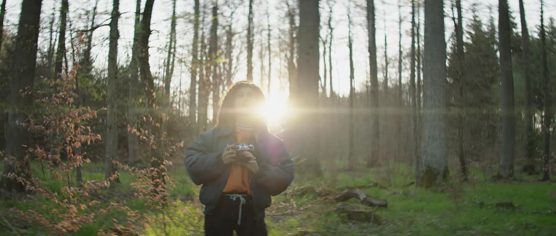 A woman with a camera in the forest taking pictures