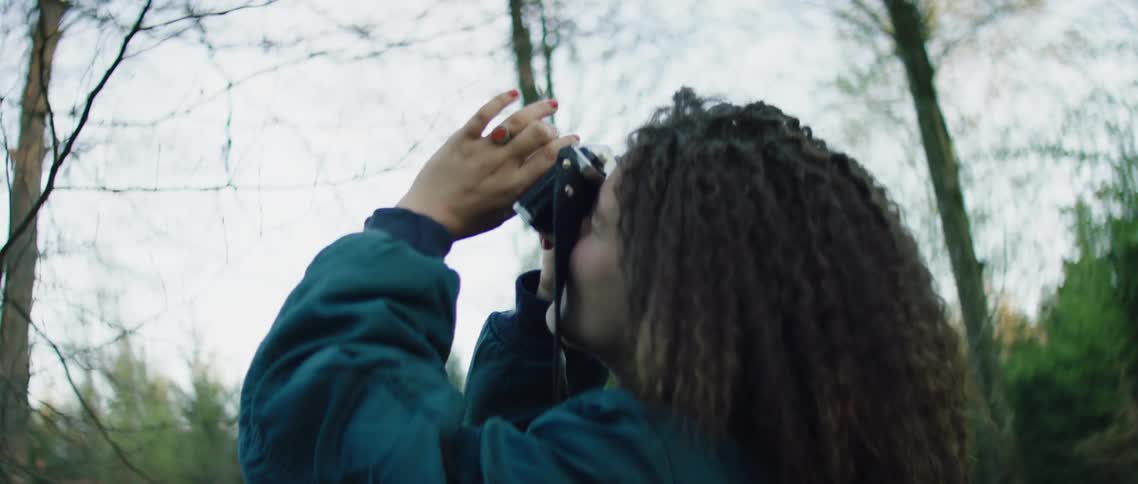 A woman takes pictures in a forest