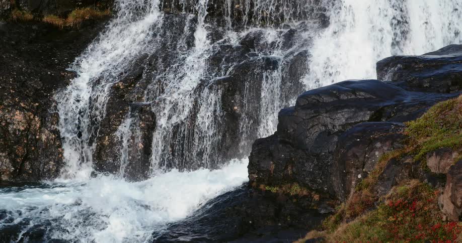 A large waterfall tumbles into rocks at the bottom of the fall