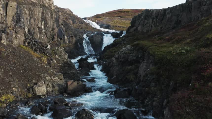 Stream rushing down series of waterfalls in canyon