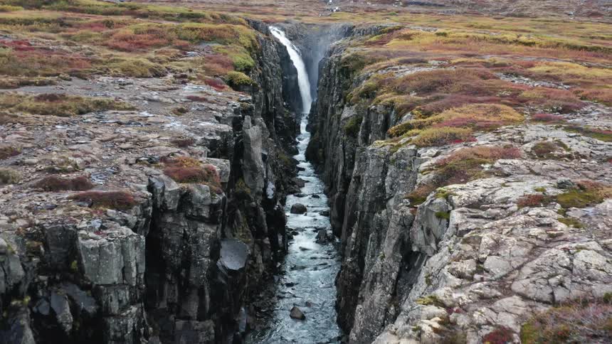 Waterfall and river in deep canyon