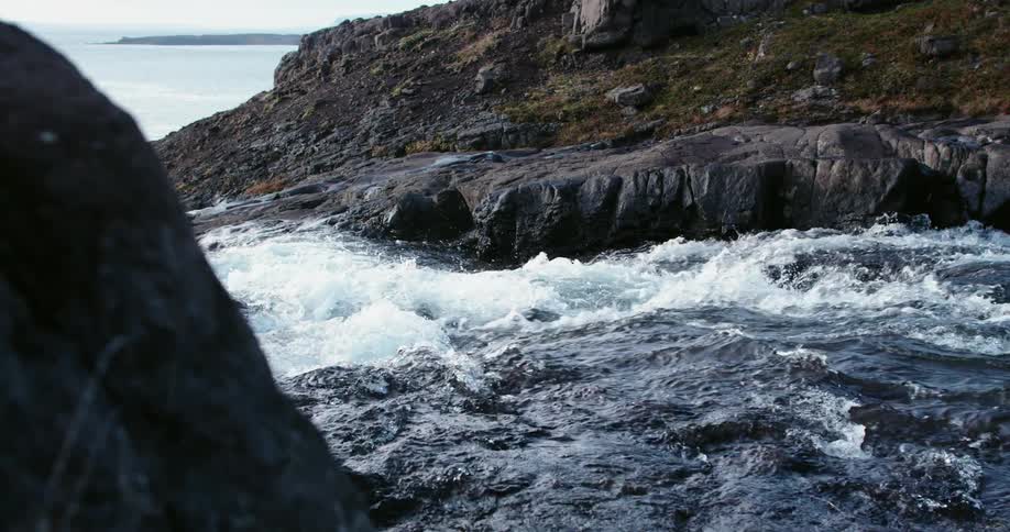 A river flows towards a big body of water