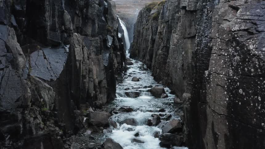 Hidden stream in a canyon gently flowing from a waterfall
