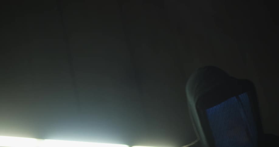 A person with a screen displaying static for a face dancing in a cement room
